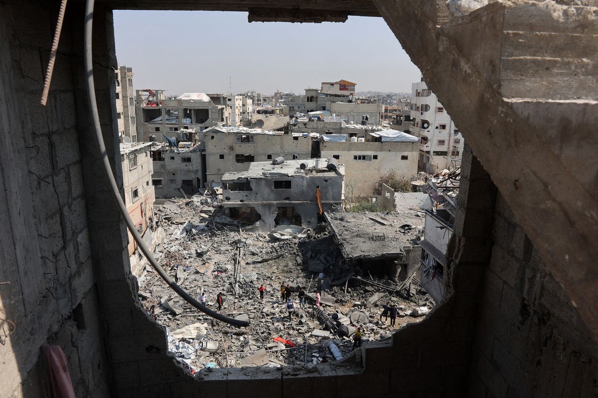 Palestinians salvage items from the destroyed house of the Qrayqea family in the Shujaiya district in eastern Gaza City on March 18, 2025, following Israeli strikes at dawn. Israel on March 18 unleashed its most intense strikes on the Gaza Strip since a January ceasefire.   (Omar Al-Qattaa/AFP/Getty Images/TNS)
