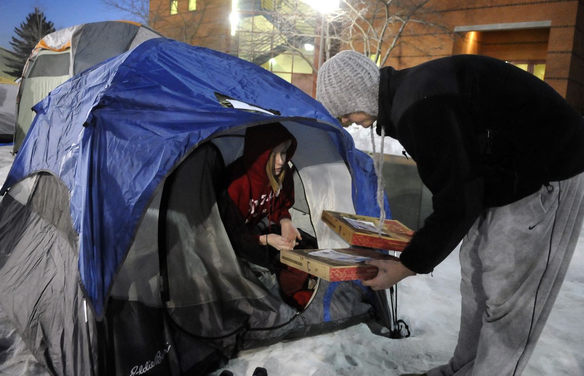 Gonzaga basketball player Matt Bouldin delivers a pepperoni pizza to Channing Parabis, 19, of Seattle, as Parabis camps Wednesday outside the McCarthey Athletic Center. Students started camping Sunday to secure the best seats at tonight’s matchup. Team members arrived with 50 pizzas and hot chocolate. (Photos by DAN PELLE / The Spokesman-Review)