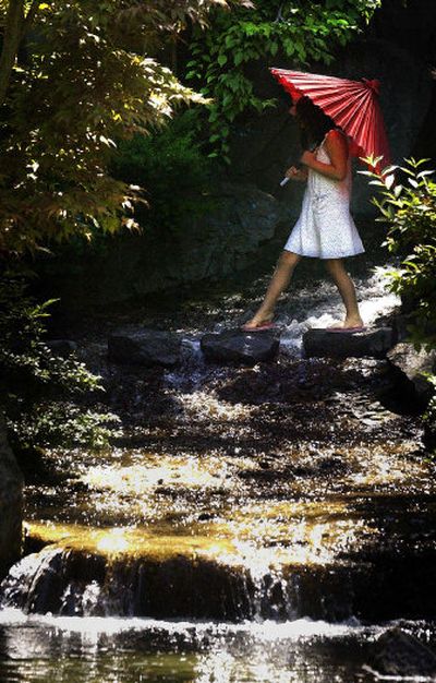 
Annabelle Young, 6, gingerly steps across a stream in Manito Park's Japanese Garden recently. The umbrella she is carrying is a gift from her brother who is in Japan.
 (Jed Conklin / The Spokesman-Review)
