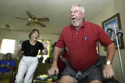 
Kent Hamilton celebrates with friend Terri Rauhaus as his son Todd wins the British Open Sunday.
 (Associated Press / The Spokesman-Review)