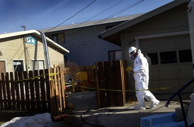 A worker for the Environmental Protection Agency enters a home in Libby, Mont., in 2005. (File / The Spokesman-Review)