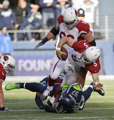 Seahawks’ Jordan Hill sacks Cardinals quarterback Drew Stanton earlier this season. (Associated Press)