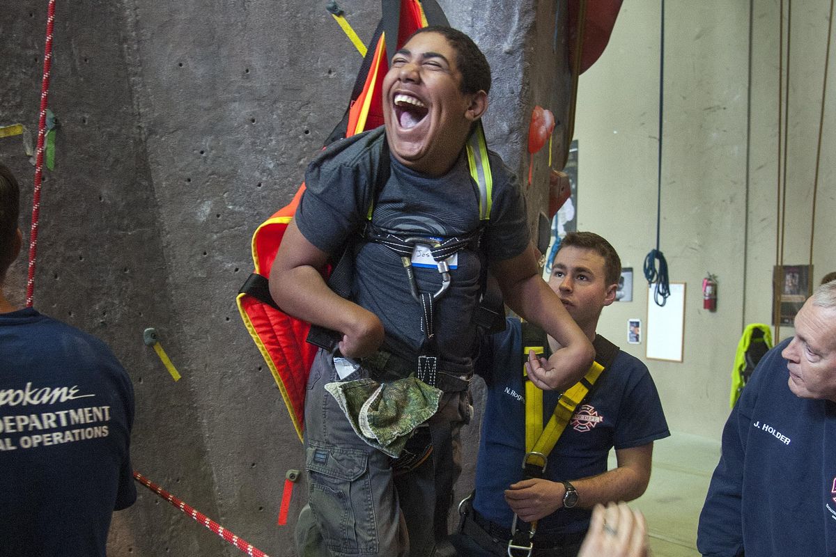 Joshua Johnston, 16, of Priest River, Idaho, beams with delight as Spokane Station 4 Tech Rescue firefighters hoist him up at Wild Walls Climbing Gym during the Courageous Kids Climbing event on April 23, 2016. (DAN PELLE/The Spokesman-Review)