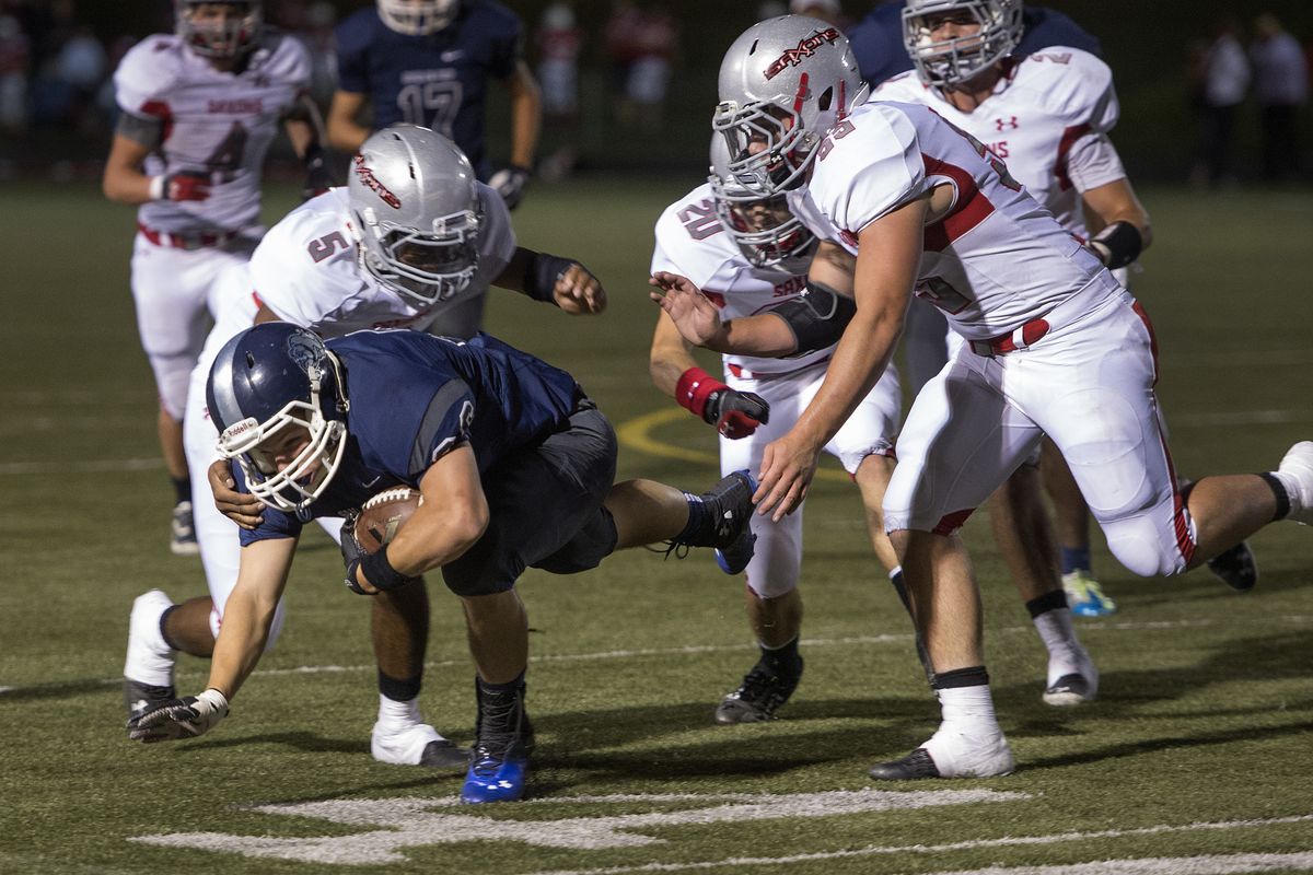 Gonzaga Prep running back Tom  Davis picks up 12-yards as Isaiah Troutt (5) of Ferris moves in for the tackle during the first half of their GSL high school football game, Friday, Sept. 20, 2013, at Gonzaga Prep High School. (Colin Mulvany / The Spokesman-Review)