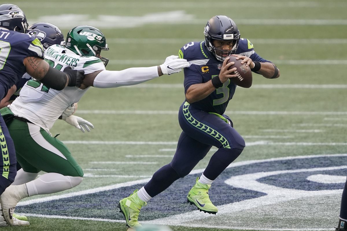 Seattle Seahawks quarterback Russell Wilson, right, scrambles against the New York Jets during the first half of an NFL football game, Sunday, Dec. 13, 2020, in Seattle.  (Associated Press)