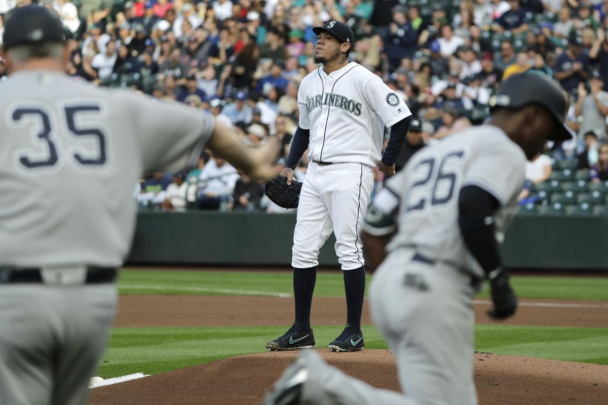 Seattle Mariners starting pitcher Felix Hernandez stands on the mound as New York Yankees right fielder Andrew McCutchen, right, passes third-base coach Phil Nevin  after McCutchen hit a solo home run during the first inning  Saturday in Seattle. (Ted S. Warren / AP)