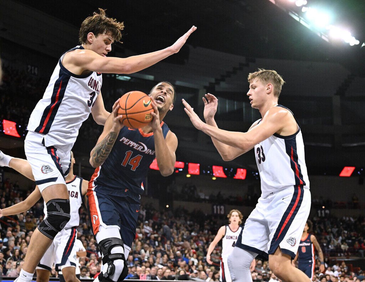 Gonzaga forward Braden Huff (34) and Gonzaga forward Ben Gregg (33) stop a shot by Pepperdine forward Jevon Porter (14) during the second half of a NCAA college basketball game, Thursday, Jan. 4, 2024, in the Spokane Veterans Arena.  (Colin Mulvany / The Spokesman-Review)