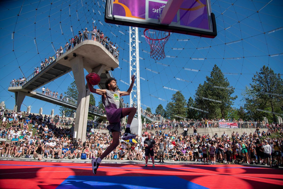 Contestant Tyler Cronk flies to the hoop, preparing for a windmill slam to win the Hoopfest 2022 slam dunk contest on June 26 under the Riverfront Park Pavilion.  (Jesse Tinsley/THE SPOKESMAN-REVIEW)