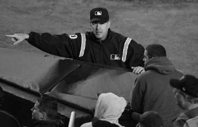 
Second-base umpire Paul Emmel points a security guard in the direction of a fan.  
 (Associated Press / The Spokesman-Review)