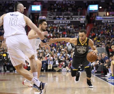 Golden State Warriors guard Stephen Curry (30) drives to the basket against Washington Wizards forward Tomas Satoransky, center, and center Marcin Gortat (13), of Poland, during the first half of an NBA basketball game Wednesday, Feb. 28, 2018, in Washington. (Nick Wass / Associated Press)