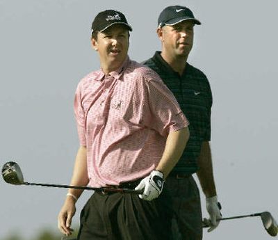 
United States' J.J. Henry, left, follows his shot beside his teammate Steward Cink on the second tee Saturday. 
 (Associated Press / The Spokesman-Review)