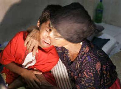 
Zulfahmi Tarmizi, 10, cries into his grandmother's arms inside a hospital in Banda Aceh. 
 (Associated Press / The Spokesman-Review)