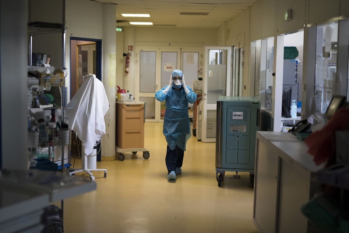 A healthcare worker wearing protective equipment walks through the intensive care unit at the Joseph Imbert Hospital Center in Arles, southern France, Wednesday, Oct. 28, 2020. Many French doctors are urging a new nationwide lockdown, noting that 58% of the country's intensive care units are now occupied by COVID patients and medical staff are under increasing strain.  (Daniel Cole)