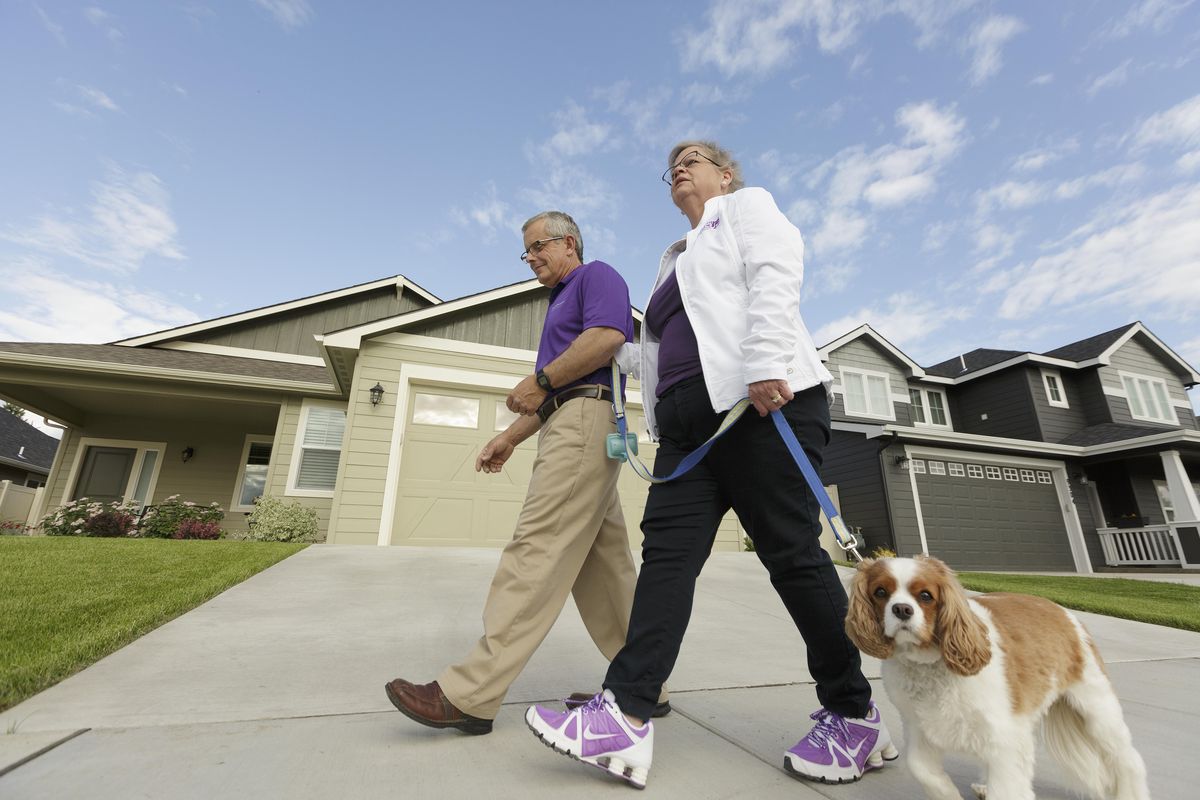 Amy Shives and her husband, George, walk their cavalier King Charles spaniel Chester in their neighborhood on June 3 in Spokane. Amy Shives was diagnosed with early onset Alzheimer’s disease in 2011 and has since been involved with the Alzheimer’s Association. Nearly two-thirds of Americans with Alzheimer’s disease are women. (Associated Press)