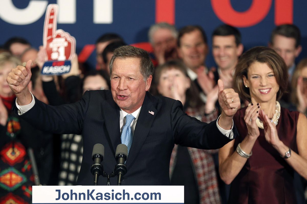 With his wife Karen at his side, Republican presidential candidate Gov. John Kasich, R-Ohio, cheers with supporters Tuesday, in Concord, N.H. (Jim Cole)