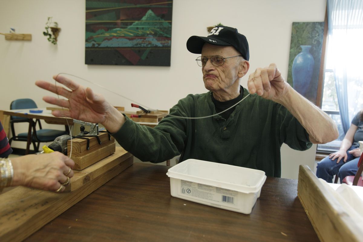 Larry Butts, 77, who has lived at the Rainier School since the day it opened in October 1939,  works at his job making twisted wires that are used with blown glass art pieces. Associated Press photos (Associated Press photos)