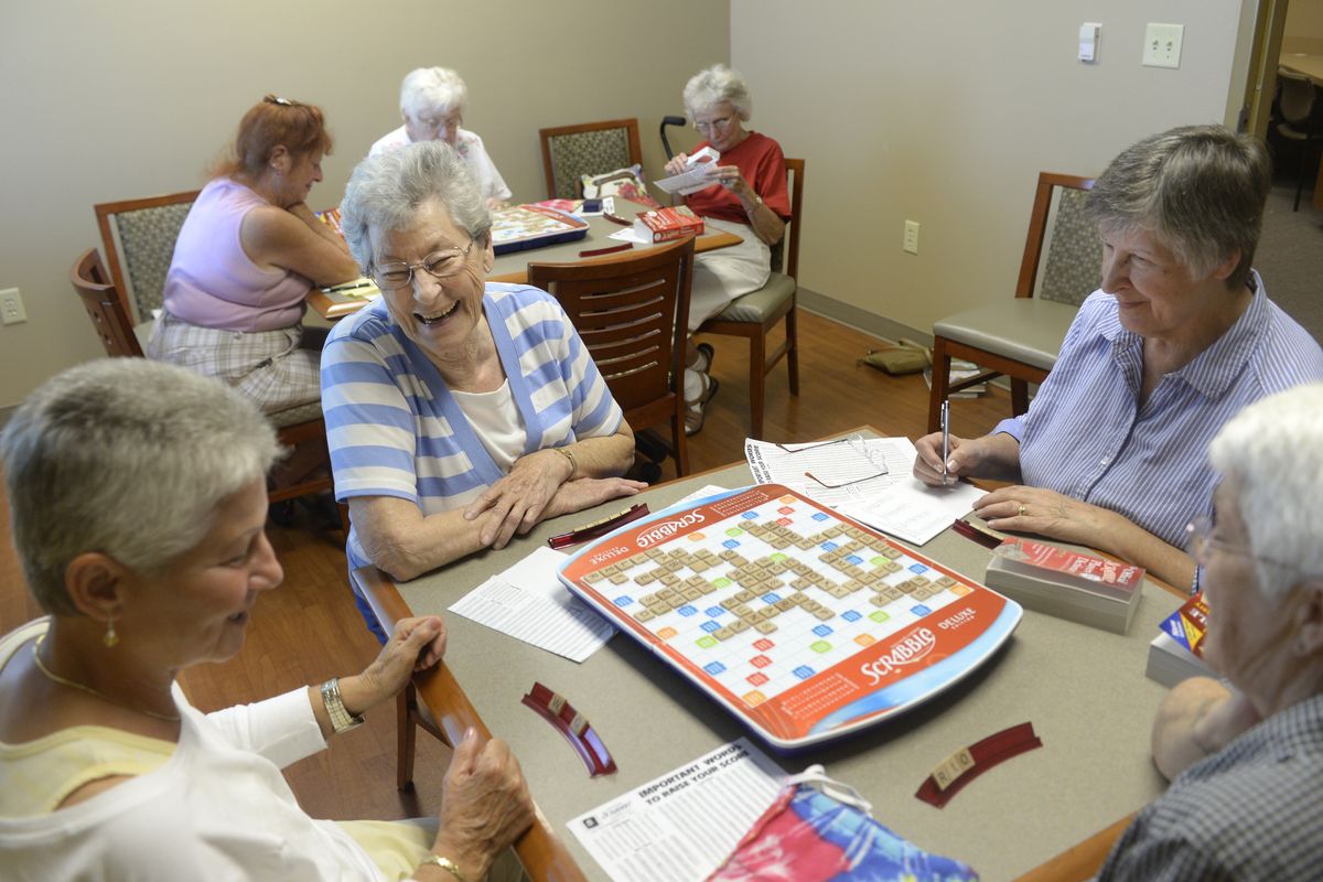 In the foreground, from left, Karen Canfield, Myrna Decker, Alice Ford and Mernie Matthews laugh over a friendly game of Scrabble on Aug. 27 at Centerplace in Spokane Valley. (Jesse Tinsley)