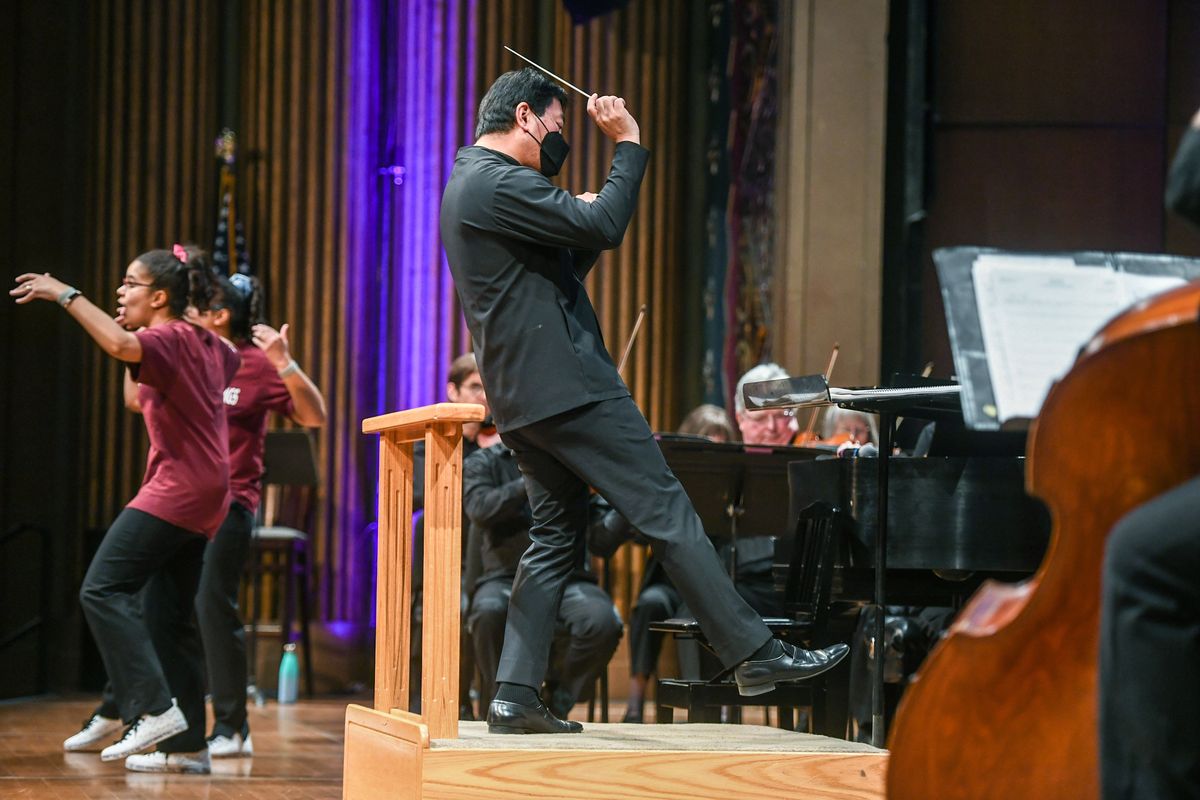 The Weddle Twins, left, and Spokane Symphony conductor Morihiko Nakahara, engage some 1100 school children in music and dance during the :Link UP’ program, Wednesday, April 26, 2023 in downtown Spokane.  (DAN PELLE/THE SPOKESMAN-REVIEW)