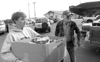 Jacob Worden, 19, carries groceries to the truck of veteran Jess Withers, who served in the Navy from 1959 to 1964.
(The Spokesman-Review)