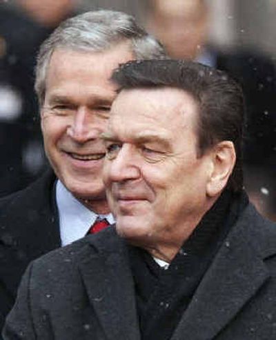 
President Bush walks behind German Chancellor Gerhard Schroeder as he introduces him to members of the U.S. delegation on Wednesday.
 (Associated Press / The Spokesman-Review)