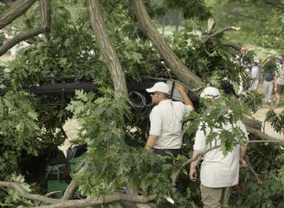 
Course officials look through the branches of a fallen tree limb near the fourth green during the PGA Championship.
 (Associated Press / The Spokesman-Review)