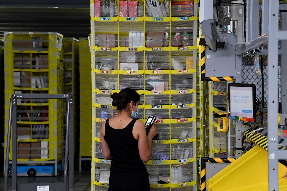 An Amazon employee scans items during a tour of Amazon’s Airway Heights fulfillment center in June 2021.  (Tyler Tjomsland/The Spokesman-Review)