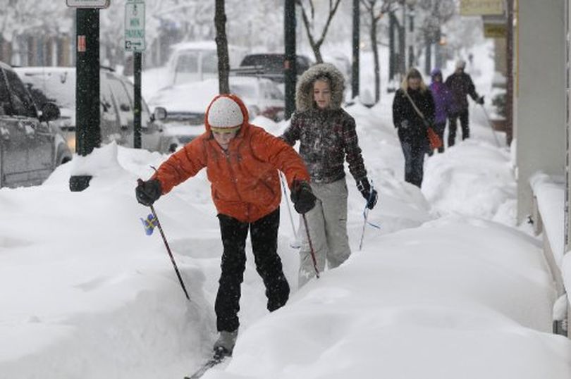 Emma Burke, 12, and Jessica Fortis, 13, ski down the sidewalks on Sherman Ave. in Coeur d'Alene Thursday as snow continued to fall from the massive snowstorm that blanked the region.  Though it was only eight days until Christmas, few shoppers braved the conditions in downtown Coeur d'Alene.  JESSE TINSLEY The Spokesman-Review (The Spokesman-Review)