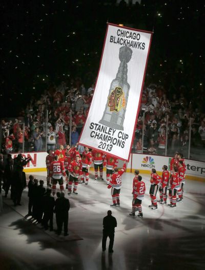 The Chicago Blackhawks watch as the Stanley Cup championship banner is lifted to the rafters. (Associated Press)