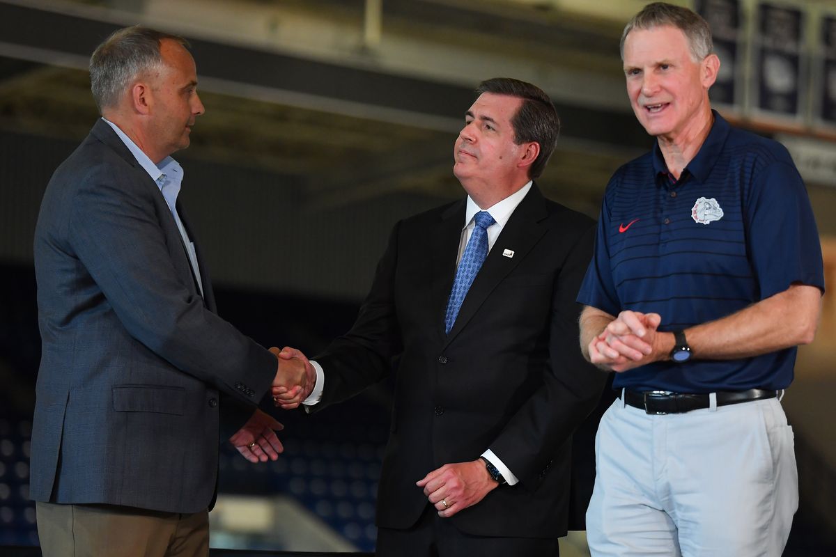 Gonzaga Athletic Director Mike Roth, right, smiles as Chris Sanford, left, shakes hands with GU president Thayne McCulloh during a news conference Tuesday to announce Roth’s retirement and introduce Standiford as his successor at McCarthey Athletic Center.  (Tyler Tjomsland/The Spokesman-Review)