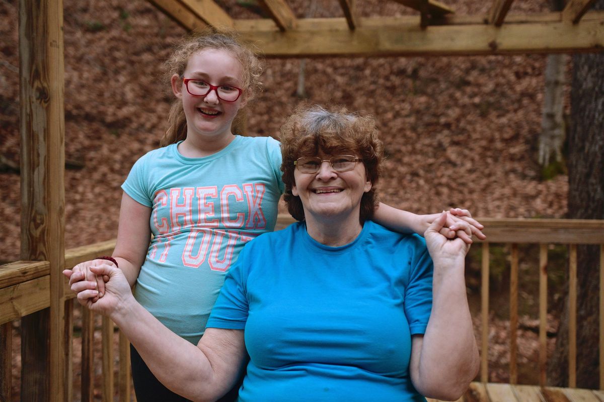 Maggie Hill, 67, poses for a portrait with a 10-year-old Charity in Madison, W.Va., on Thursday, Nov. 29, 2018. The grandmother is raising Charity, the daughter of Maggie’s son, as her own child. They live in a small wooded valley with a creek in it – a holler, as they say in West Virginia. Her house is a cabin that from the outside resembles a small, tidy barn. Charity has given her life a purpose, she said. (Tyler Evert / AP)