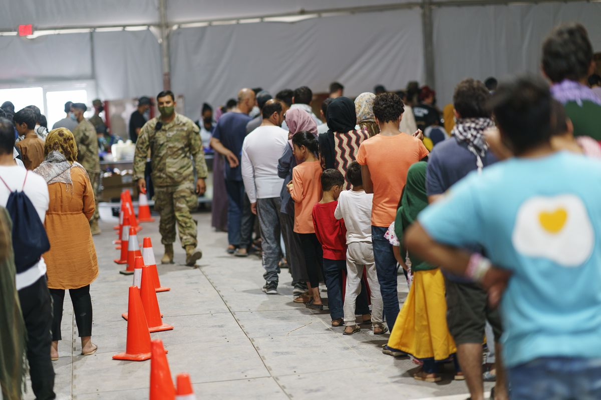 Afghan refugees line up for food in a dining hall at Fort Bliss