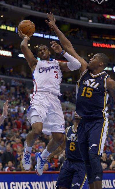 Clippers guard Chris Paul goes up for a shot as Jazz forward Derrick Favors defends. Paul scored 19 points and added nine assists. (Associated Press)