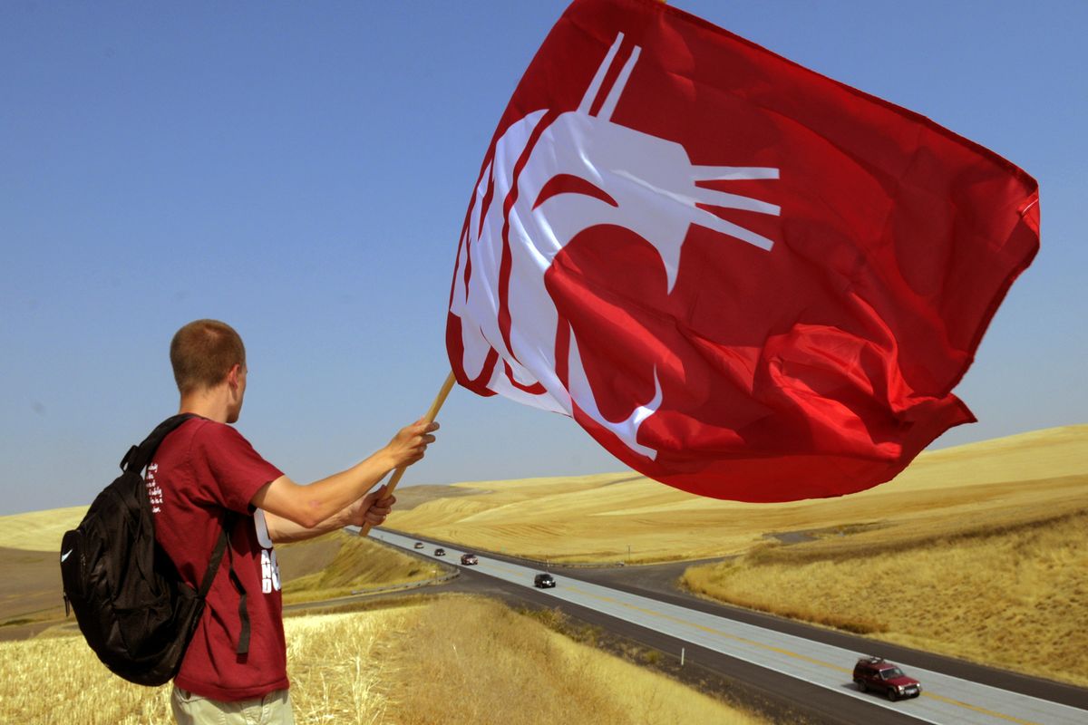 WSU student, A.J. Tullo, waves a flag at traffic headed south on Highway 195 at the Steptoe area, Saturday, Sept. 10, 2011.  Tullo was one of about 70 students from Coug Guys and Gals which is comprised of students supporting the athletic department who were out showing some support for the WSU vs. UNLV football game at Martin Stadium on the WSU campus. (Christopher Anderson / Spokesman-Review)