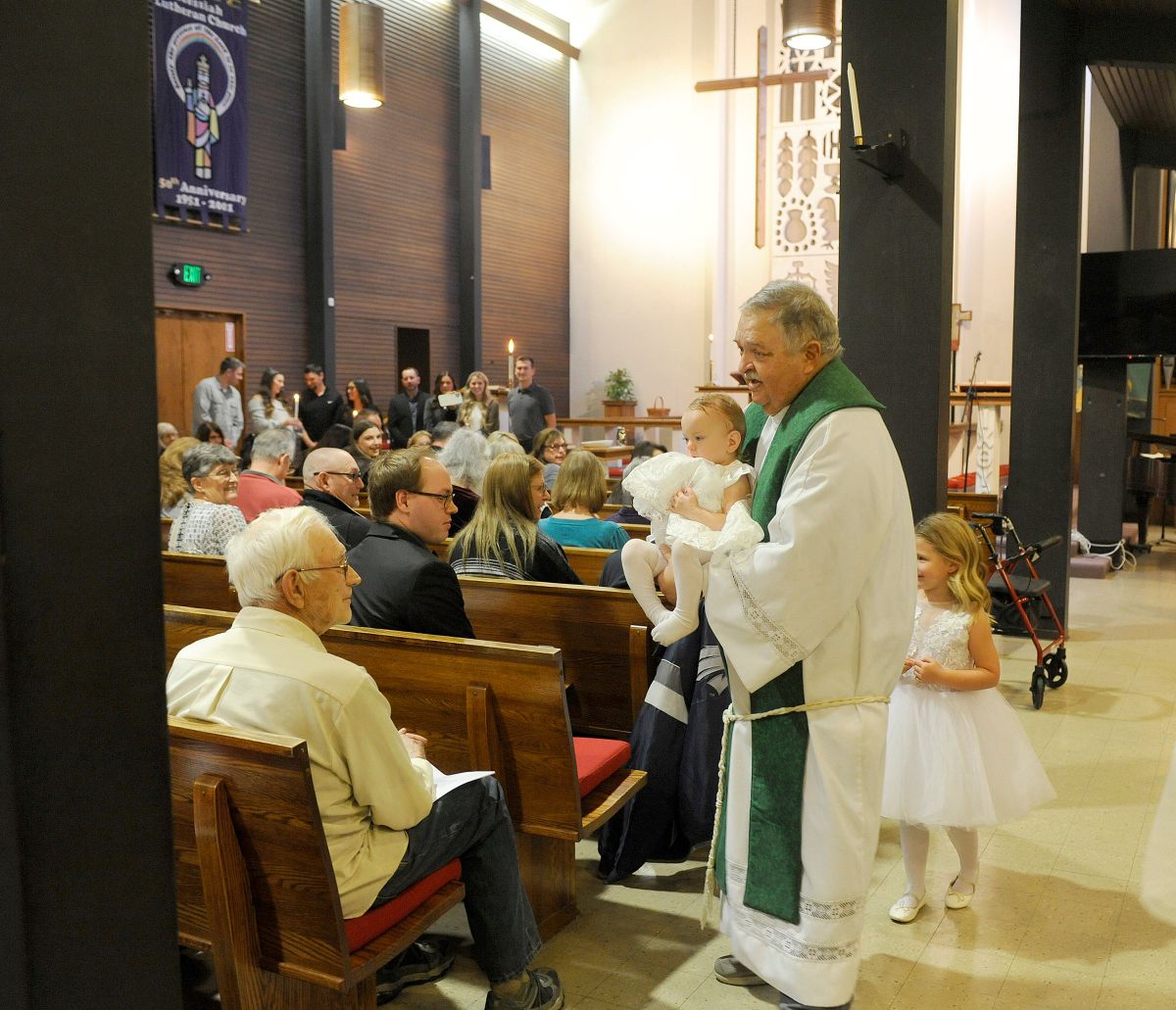 Pastor Bob Kenyon baptized Lakelynn Bremner, in pastor’s arms, and Hadley Nicole Wheeler, behind the pastor, on Nov. 10 at Messiah Evangelical Lutheran Church. Pastor Kenyon walked the two children around the congregation to introduce them after the ceremony. After 73 years on the north side of Spokane, the Church is selling the building.  (Christopher Anderson/For the Spokesman-Review)