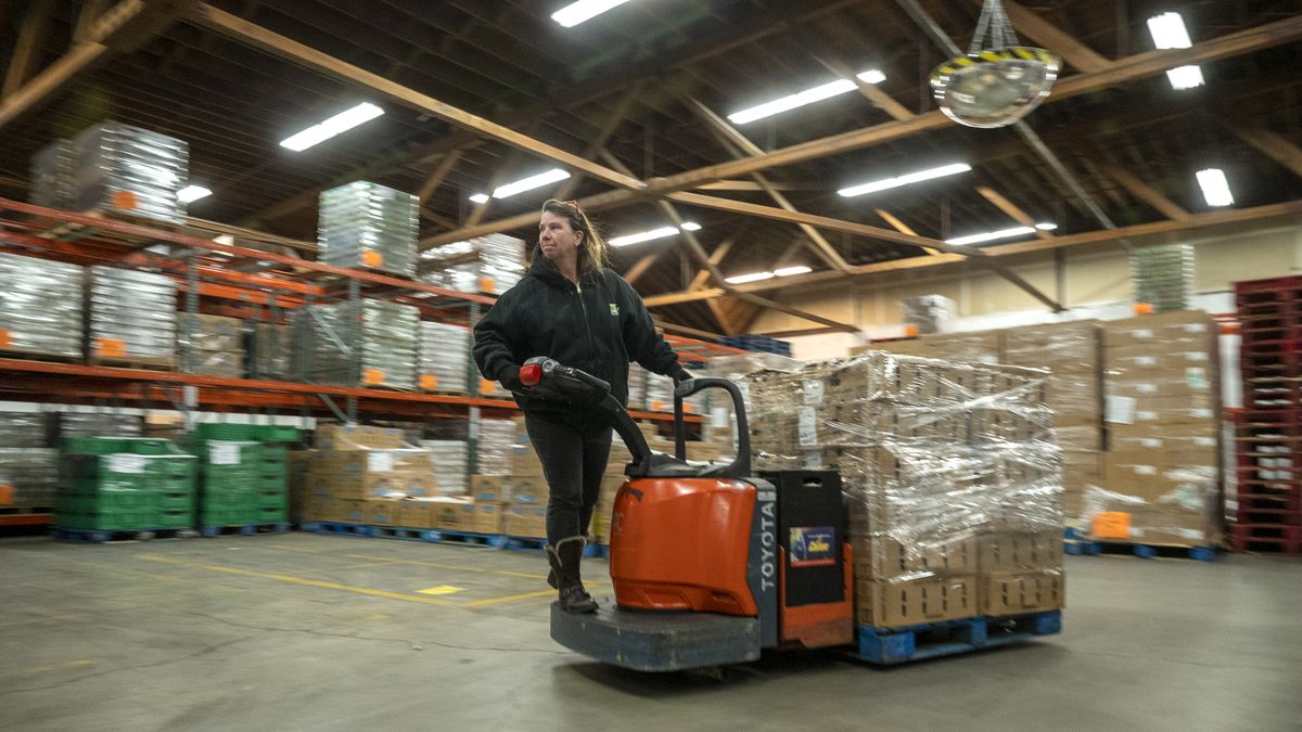 Barbara Kent maneuvers pallets of food using a pallet jack at the Second Harvest warehouse Nov. 7, 2022 in Spokane. The regional food bank supply distributor is facing higher prices and some shortages in produce and commodities.  (Jesse Tinsley/THE SPOKESMAN-REVI)
