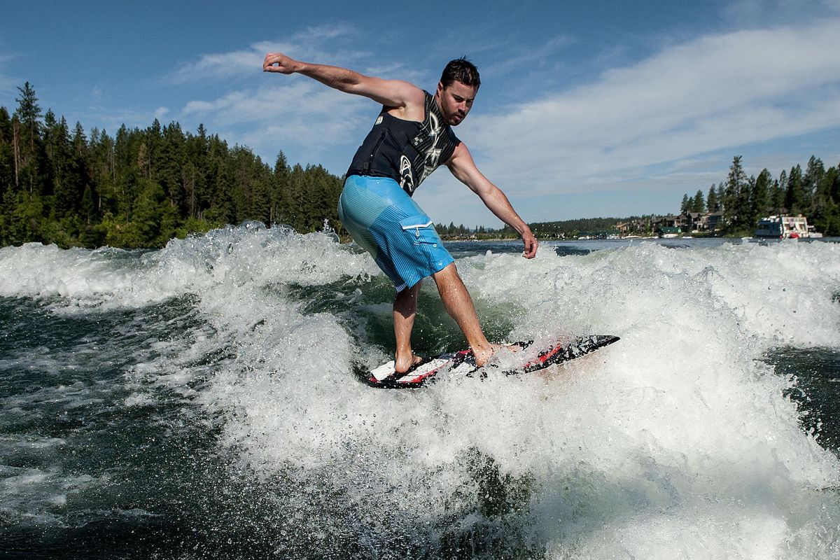 Jarrett Moss, of StanCraft Marine, demonstrates wake boarding on the Spokane River in Coeur d