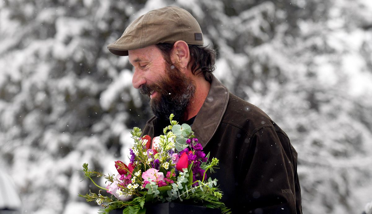 Rex Shute carries a Valentine’s Day bouquet for his wife, Dollie Shute, that he bought from Flowers By Paul in Post Falls, Idaho, on a snowy Wednesday, Feb. 14, 2018. The Spokane area received record snow that day. (Kathy Plonka / The Spokesman-Review)