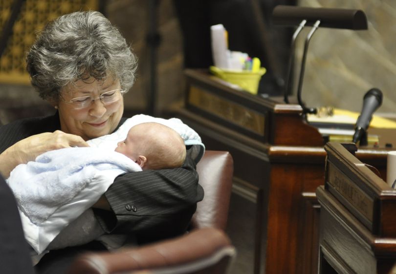 OLYMPIA -- Sen. Maralyn Chase, D-Shoreline, holds Henry Schlicher on the floor of the Senate while his father, Sen. Nathan Schlicher, D-Gig Harbor, handles a motion during debate Saturday. (Jim Camden)