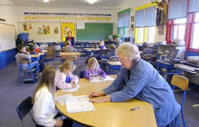 
Dorothy Harrison, right, works with the youngest students recently  at Idaho's one-room Tendoy School while teacher Jenny Peterson, back, teaches the older students in Tendoy, Idaho. For 90 years, the school has sucessfully served children from the rural Lemhi Valley. 
 (Associated Press / The Spokesman-Review)