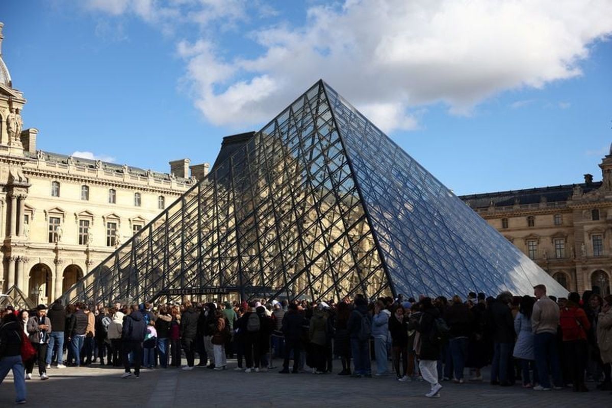 People stand outside the Louvre Museum, after French police arrested suspects in the Louvre heist case, in Paris on Sunday. (Reuters )