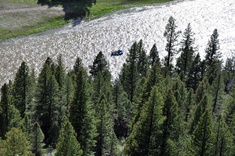 A raft carring anglers is put in perspective in this shot from high above on top of a rock cliff overlooking the Smith River. (Rich Landers)