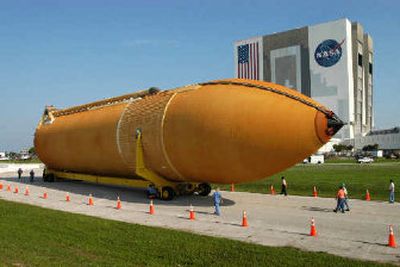 
This photo released by NASA shows a newly designed external fuel tank being towed to the vehicle assembly building, right, at Kennedy Space Center in Cape Canaveral, Fla., on Monday. The tank arrived from the Michoud Assembly Facility in New Orleans and will be used for a future space shuttle mission.
 (Associated Press / The Spokesman-Review)