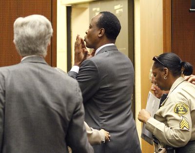 Dr. Conrad Murray, center, blows a kiss to an unidentified member of the courtroom audience after he was sentenced today to four years in county jail for his involuntary manslaughter conviction in the death of pop star Michael Jackson in Superior Court in Los Angeles. (AP Photo/Mario Anzuoni, Pool)