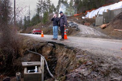 
Engineer Scott Jamar, left, and Joe Wuest look at the damage to Upper Hayden Lake Road. 
 (The Spokesman-Review)