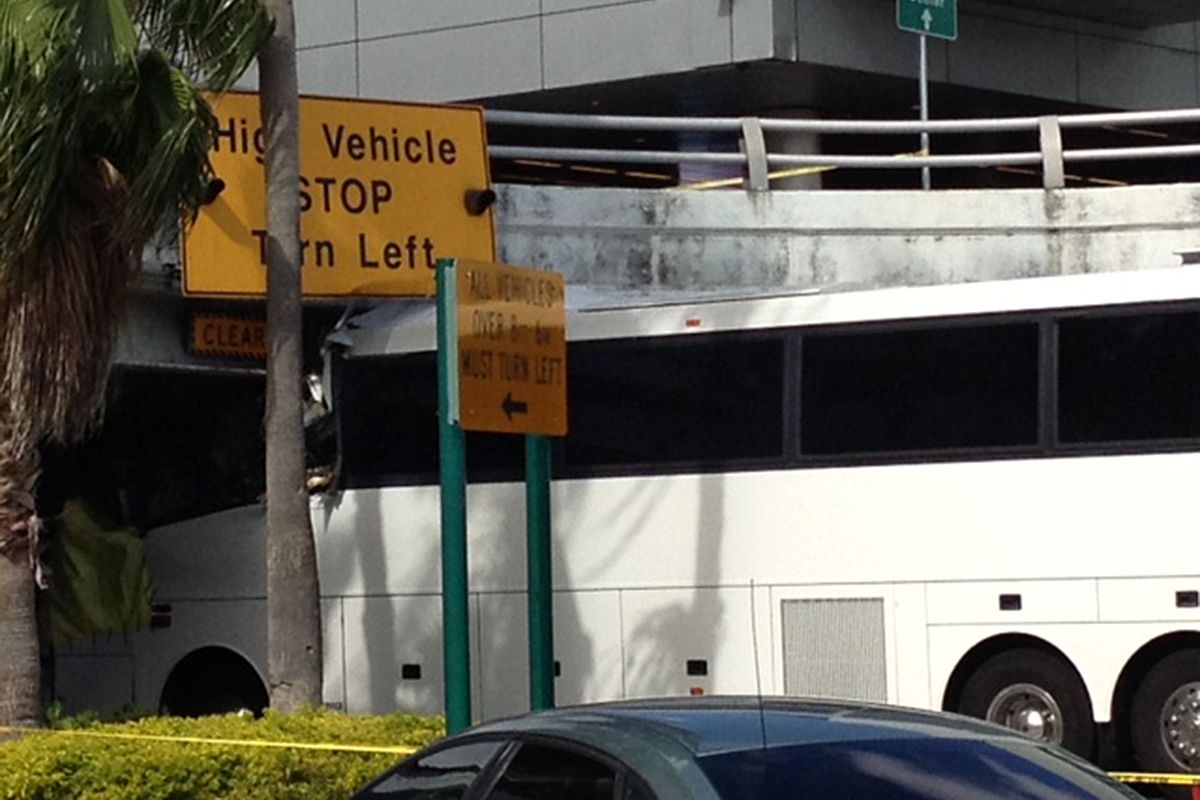 A bus is lodged into an overpass at the Miami International Airport on Saturday, Dec. 1, 2012. The vehicle was carrying over 30 people when it crashed into the structure. Authorities say buses typically are routed through the departures area, which has a higher clearance. (Suzette Laboy / Associated Press)