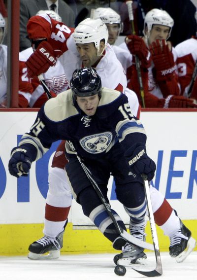 Columbus Blue Jackets’ Derek Dorsett, front, carries the puck up ice as Detroit Red Wings’ Todd Bertuzzi defends. (Associated Press)