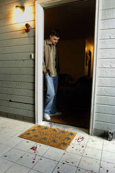 
Jared Eaton stands at his apartment door looking at the blood stains from the shooting of Eric McMillan Sunday. McMillan was shot at his own apartment and made his way downstairs to Eaton's apartment looking for help. 
 (Christopher Anderson/ / The Spokesman-Review)