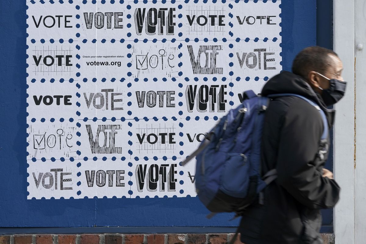 A pedestrian passes by a mural encouraging people to in Washington state to vote, Tuesday, Oct. 13, 2020, in downtown Seattle. A record number of voters in Washington have already returned their ballots as of Friday, Oct. 30, 2020, and other voters have until 8 p.m. Tuesday, Nov. 3, 2020 to drop off or mail their ballots or vote in person.  (Ted S. Warren)
