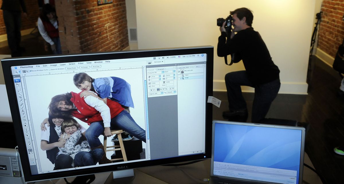 Jed Conklin shoots pictures of people participating in Help-Portrait, a worldwide project where professional photographers offer their skills for free, on Saturday at the Saranac Arts Projects gallery in downtown Spokane. On the computer screen, Christine Fort strikes a pose with her sons, Alex (top right) and Steven, and their friend Travis Moad (far left).danp@spokesman.com (PHOTOS BY DAN PELLE)