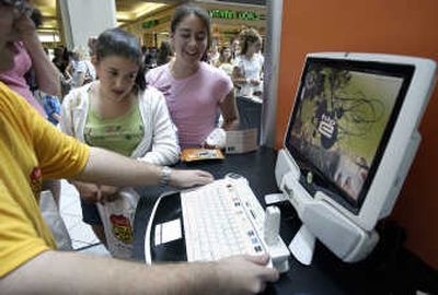 Alexis Sohinkik, 13, of Norfolk, Mass., center, and Kim Enos, 13, of Cranston, R.I., right, watch a computer screen. Teens rank friends, family, God, pets and pastimes ahead of money, according to a poll released Tuesday.Associated Press
 (Associated Press / The Spokesman-Review)